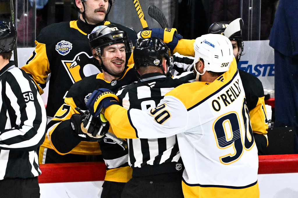 Penguin's Sidney Crosby scuffles with Predator's Ryan O'Reilly, right, during the NHL Global Series hockey game between the Pittsburgh Penguins and the Nashville Predators in Stockholm, Sweden, Sunday, Nov. 16, 2025. (Claudio Bresciani/TT News Agency via AP)