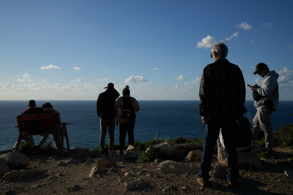 People gather at a lookout to look for the possible arrival of the US Navy's aircraft carrier USS Gerald R. Ford in the Mediterranean Sea near the coast of Haifa, northern Israel, Friday, Feb. 27, 2026. (AP Photo/Leo Correa)
