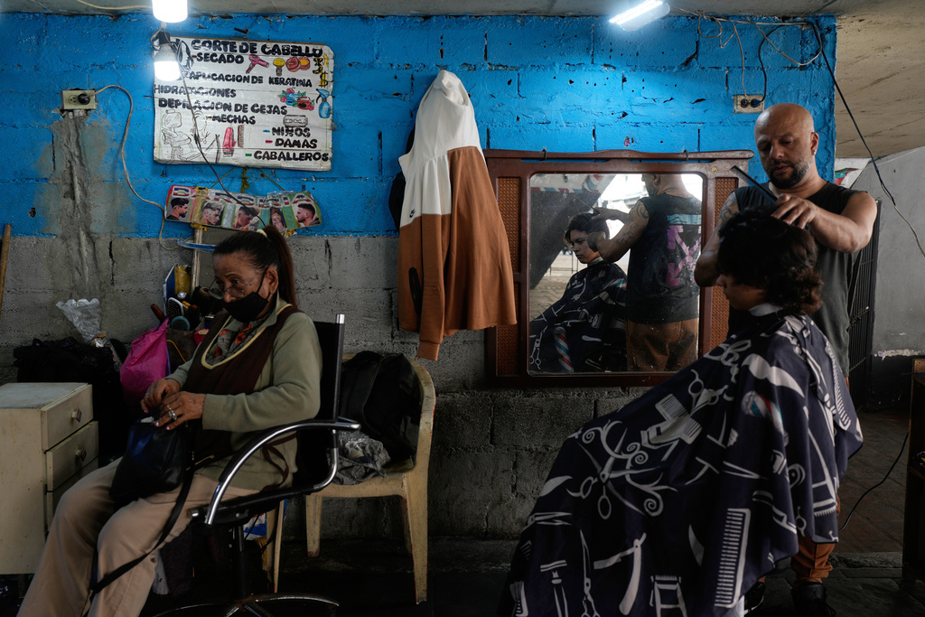 A barber cuts hair at a barbershop in Caracas, Venezuela, Tuesday, Jan. 6, 2026. (AP Photo/Matias Delacroix)