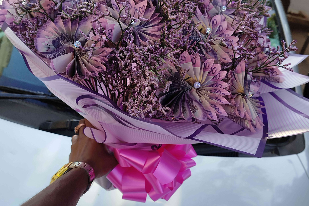 A vendor holds a flower bouquet that incorporates real money in Nairobi, Kenya, Nov. 25, 2025. (AP Photo/Duke Monari)