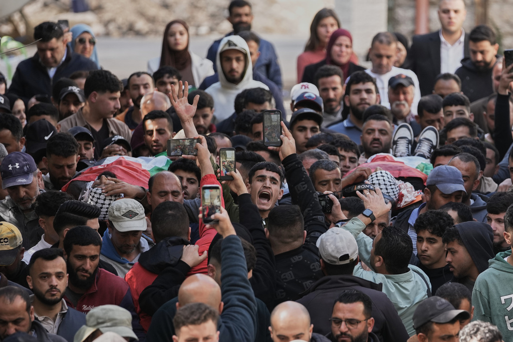 Mourners carry the bodies of Aws al-Na'san and Jihad Abu Naim, residents of the West Bank village of al-Mughayyir, out of the hospital's morgue in the West Bank city of Ramallah, Tuesday, April 21, 2026. (AP Photo/Mahmoud Illean)