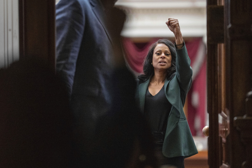 Rep.Nicole Collier, D-Fort Worth, raises a fist as she greets supporters from inside the House Chamber at the Texas Capitol in Austin, Tuesday, Aug. 19, 2025. (Mikala Compton/Austin American-Statesman via AP)