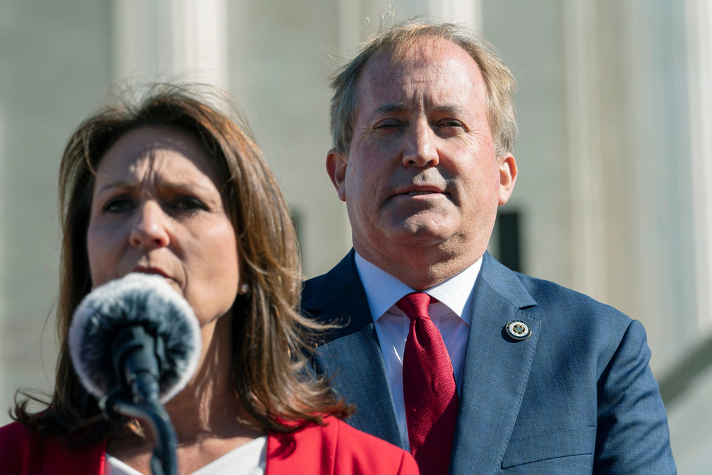 FILE - Texas Attorney General Ken Paxton, right, listens as his wife, Texas State Sen. Angela Paxton, speaks to anti-abortion activists at a rally outside the Supreme Court in Washington on Nov. 1, 2021. (AP Photo/Jacquelyn Martin, File)