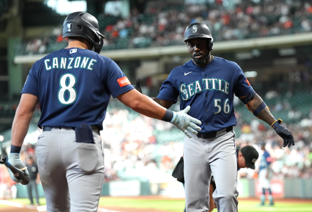 Seattle Mariners' Randy Arozarena (56) celebrates after his home run with Dominic Canzone (8) during the first inning of a baseball game against the Houston Astros, Sunday, Aug. 16, 2026, in Houston. (AP Photo/Karen Warren)