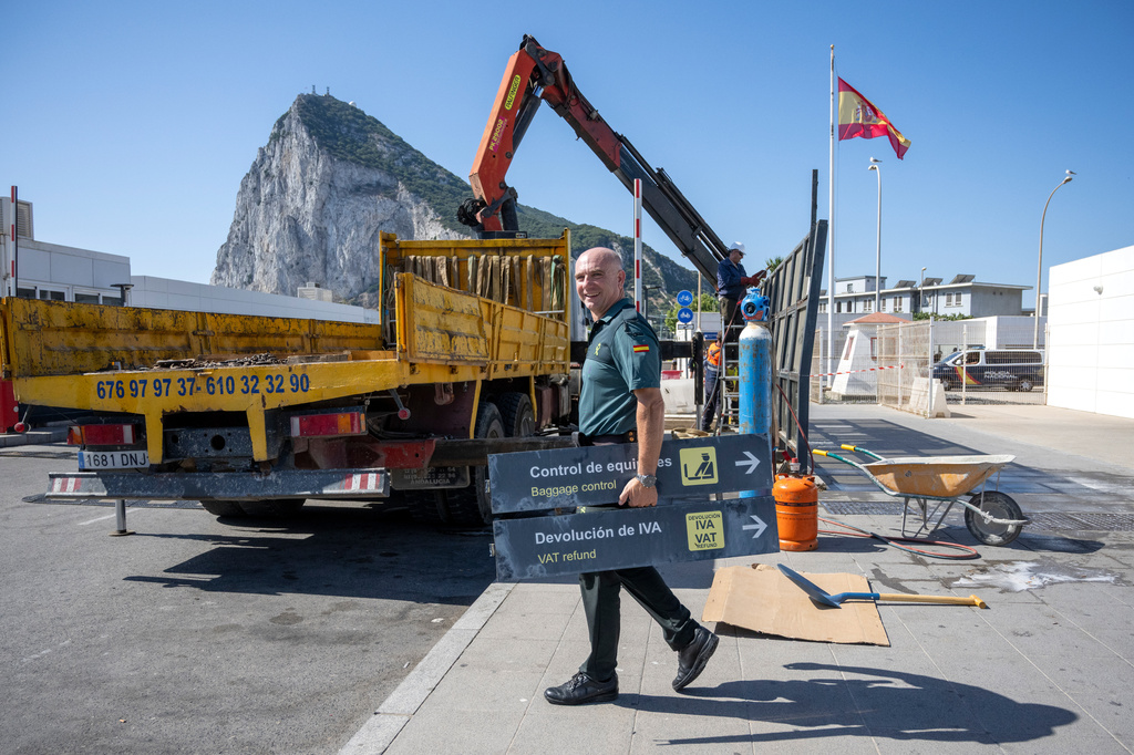 A Spanish Guardia Civil officer holds a sign during the dismantling of a border checkpoint that separated Spain from the disputed British overseas territory of Gibraltar in La Línea de la Concepción, Spain, Monday, July 6, 2026. (AP Photo/Marcos Moreno)
