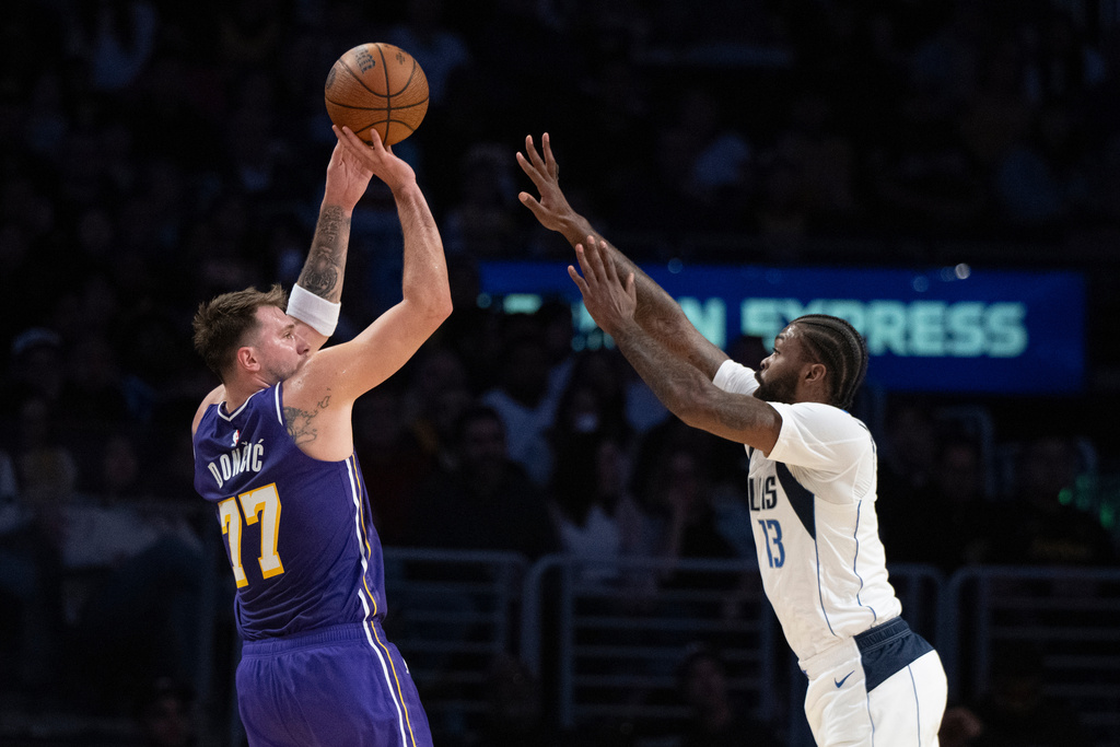 Los Angeles Lakers guard Luka Doncic (77) shoots as Dallas Mavericks forward Naji Marshall (13) defends during the first half of an NBA Cup basketball game in Los Angeles, Friday, Nov. 28, 2025. (AP Photo/Kyusung Gong)