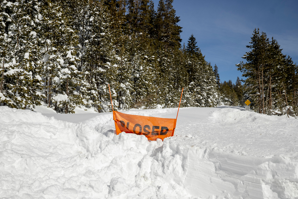 A closed sign is partially buried at the entrance to the Castle Peak trailhead in Soda Springs, Calif., Friday, Feb. 20, 2026. (Stephen Lam/San Francisco Chronicle via AP)