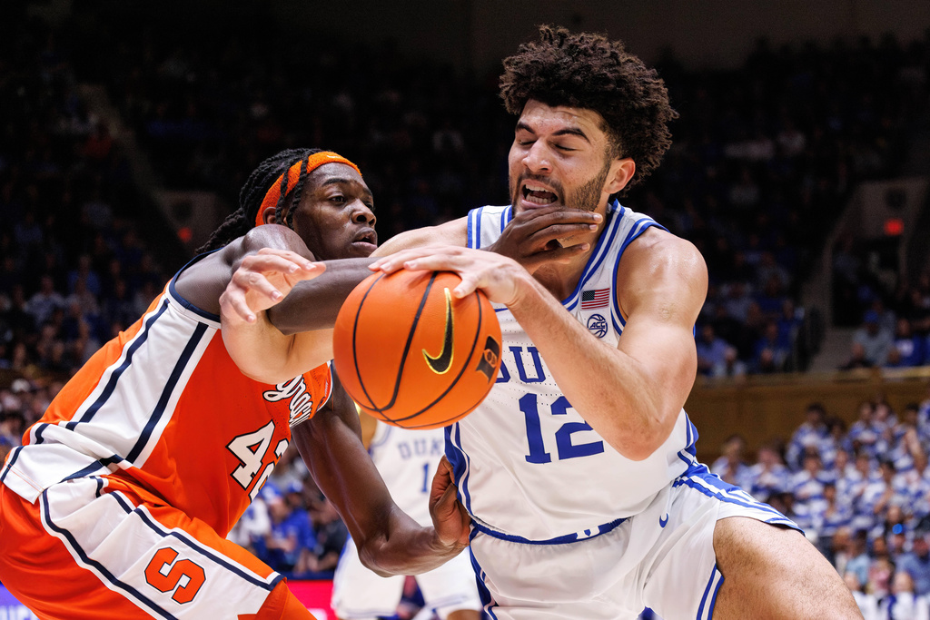 Duke's Cameron Boozer (12) handles the ball as Syracuse's William Kyle III, left, defends during the second half of an NCAA college basketball game in Durham, N.C., Monday, Feb. 16, 2026. (AP Photo/Ben McKeown)
