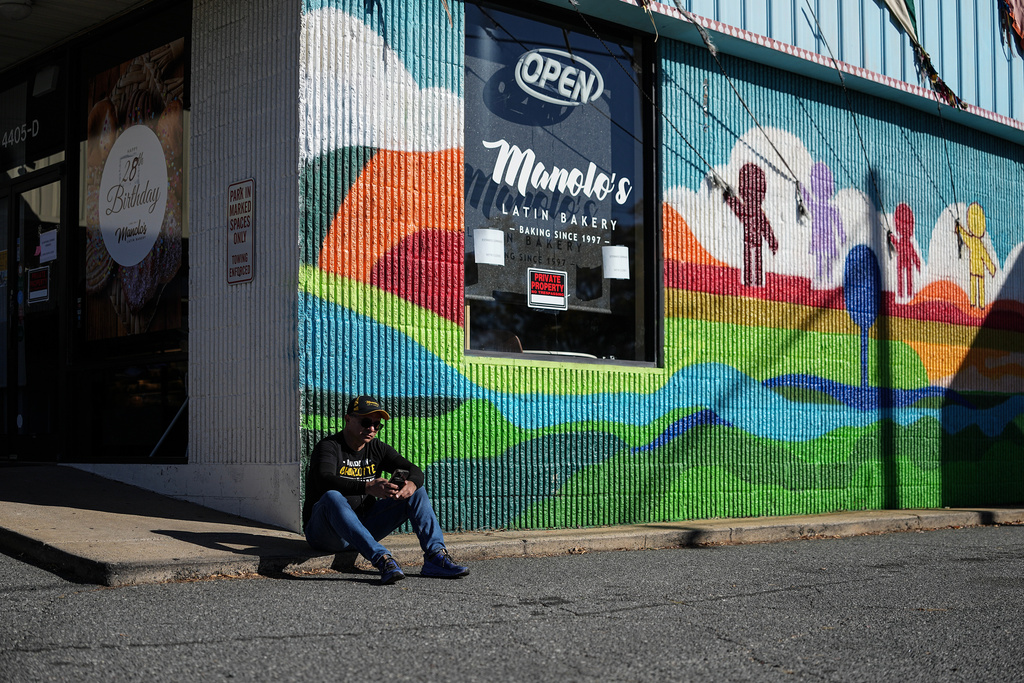 Manuel 'Manolo' Betancur sits outside of his bakery which is closed amidst federal law enforcement presence, Monday, Nov. 17, 2025, in Charlotte, N.C. (AP Photo/Matt Kelley)