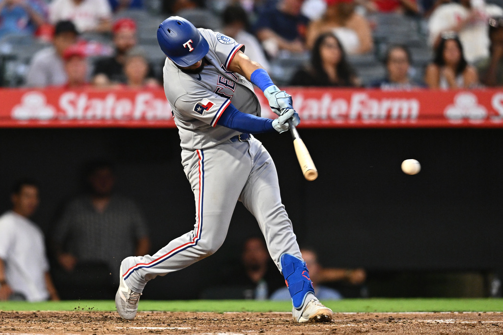 Texas Rangers' Elias Díaz hits an RBI single during the fourth inning of a baseball game against the Los Angeles Angels, Monday, Aug. 10, 2026, in Anaheim, Calif. (AP Photo/William Liang)