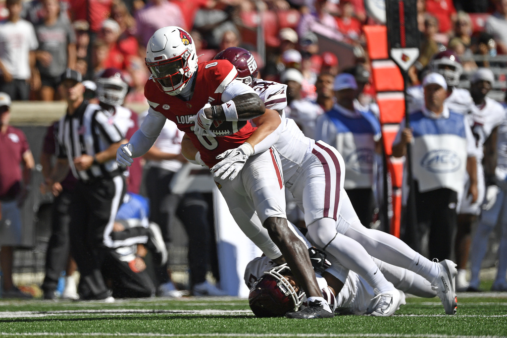Louisville wide receiver Chris Bell (0) is brought down from behind by Eastern Kentucky linebacker Brody Wells (34) during the first half of an NCAA college football game in Louisville, Ky., Saturday, Aug. 30, 2025. (AP Photo/Timothy D. Easley)