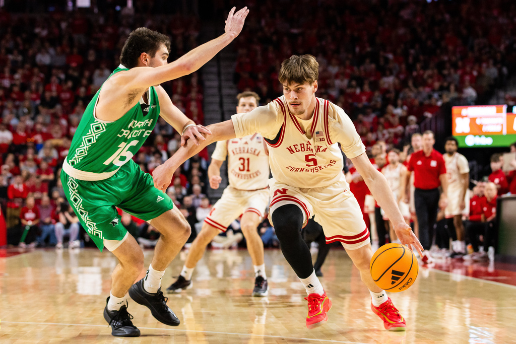 Nebraska forward Braden Frager (5) drives against North Dakota guard Garrett Anderson (16) during the first half of an NCAA college basketball game, Sunday, Dec. 21, 2025, in Lincoln, Neb. (AP Photo/Bonnie Ryan)