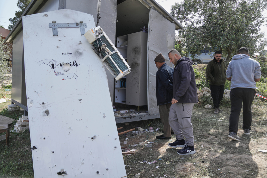 Palestinians inspect the damage at a beauty salon after a deadly Iranian strike in the West Bank village of Beit Awa, near Hebron, Thursday, March 19, 2026. (AP Photo/Mahmoud Illean)