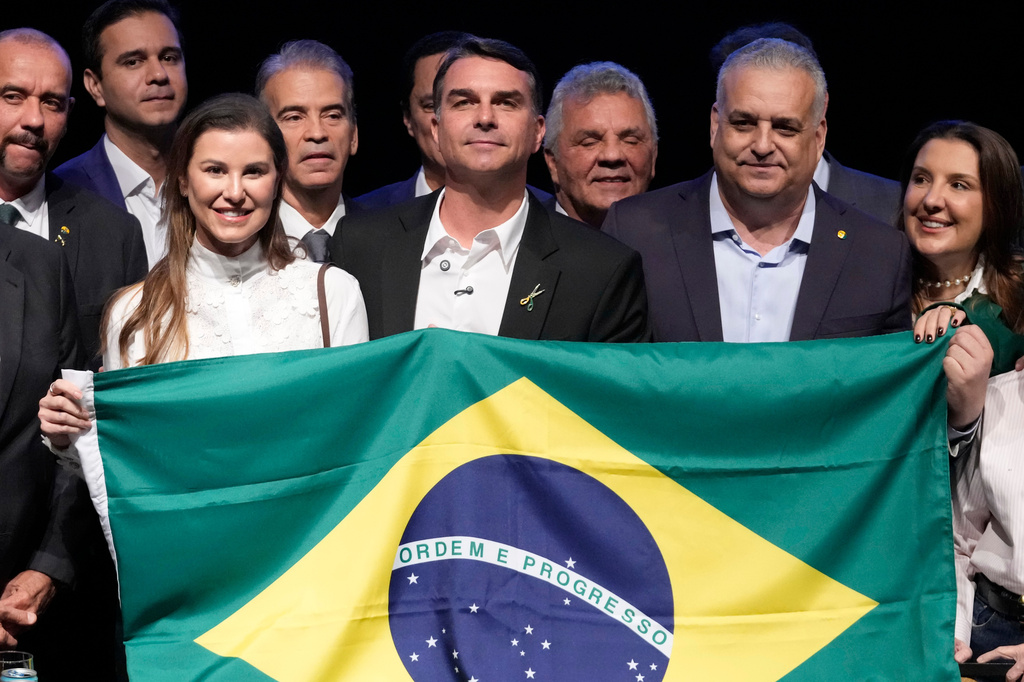 Brazilian presidential candidate Flavio Bolsonaro, center, poses for a photo with his wife Fernanda Bolsonaro, left, running mate Alfredo Gaspar, right, at en event to announce his ticket in Brasilia, Brazil, Wednesday, Aug. 5, 2026. (AP Photo/Eraldo Peres)