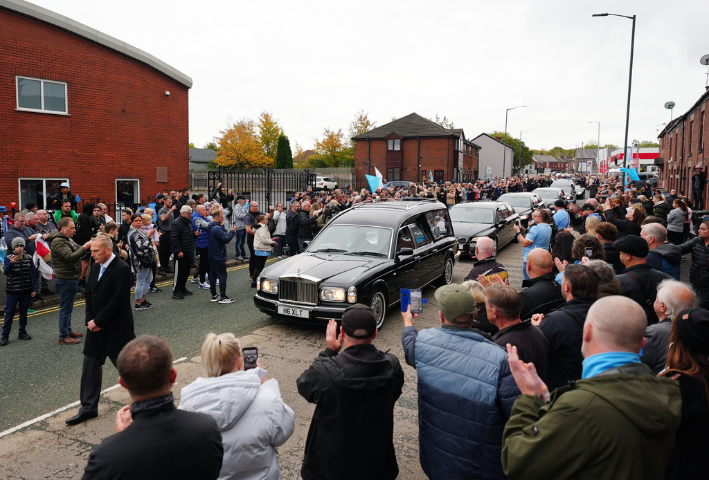 The hearse stops outside Hatton's Gym in Hyde, during a procession, ahead of a funeral service for former boxing champion Ricky Hatton at Manchester Cathedral, England, Friday Oct. 10, 2025. (Owen Humphreys/PA via AP)