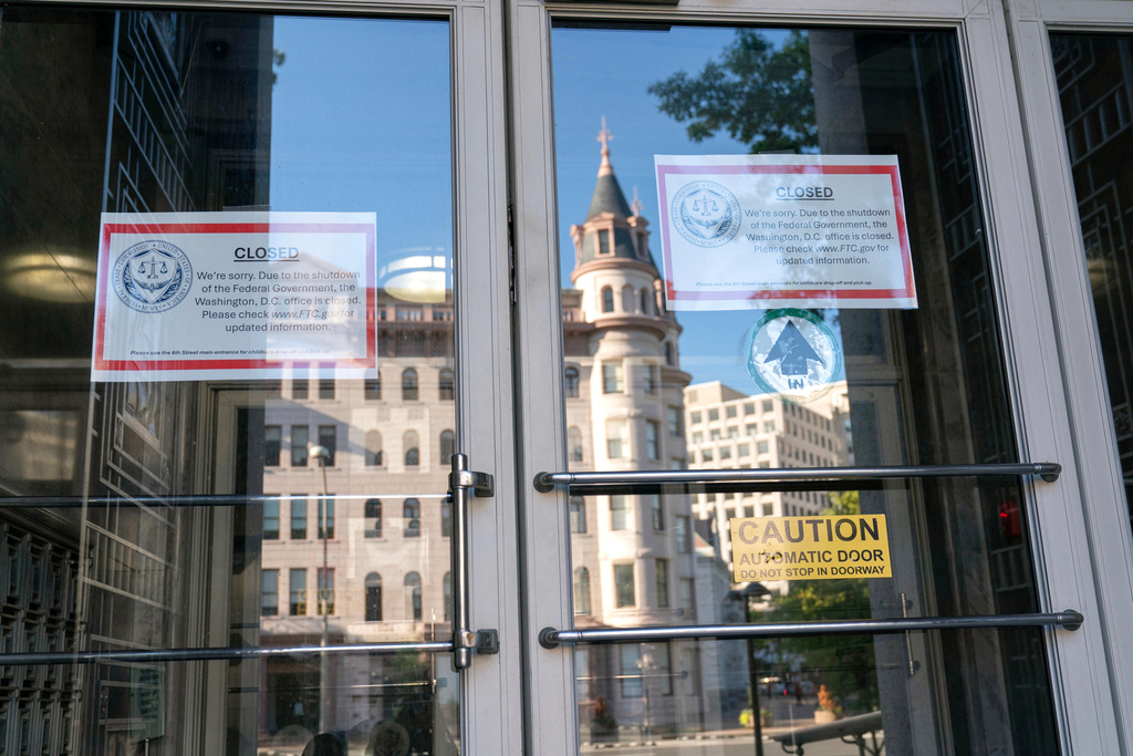 Signs that read, "We're sorry. Due to the shutdown of the Federal Government, the Washington, D.C. office is closed." is seen on the doors of the Federal Trade Commission building on the six day of the government shutdown, in Washington, Monday, Oct. 6, 2025. (AP Photo/Jose Luis Magana)