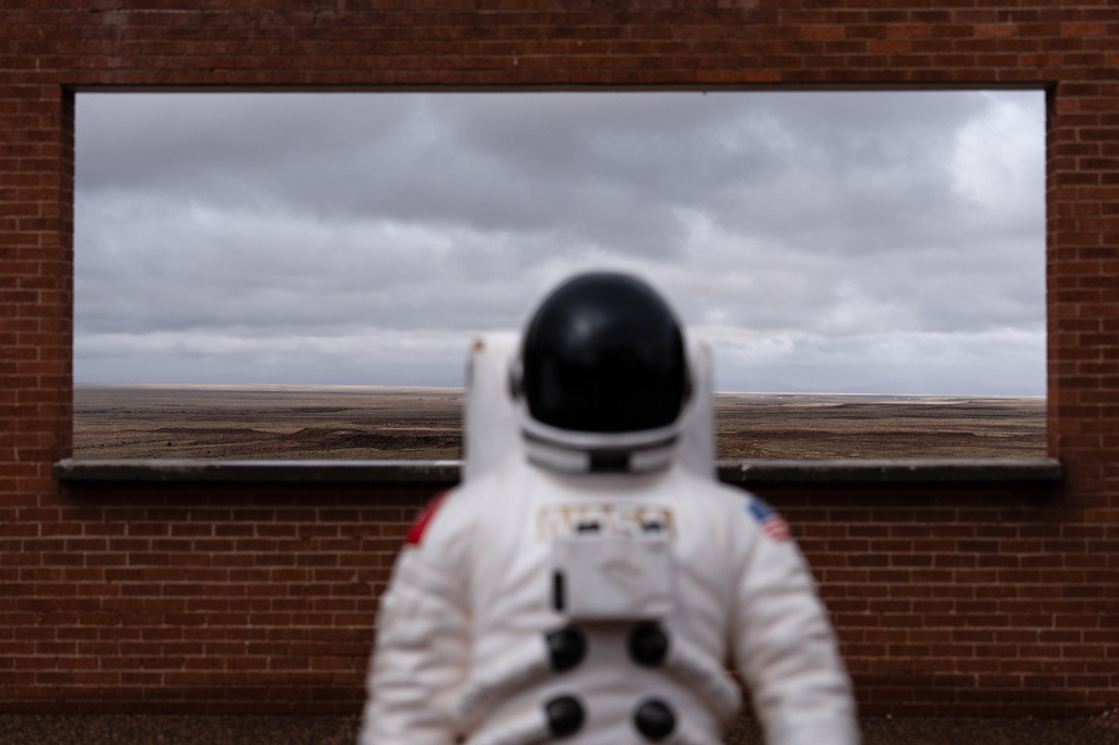 An astronaut figure is placed in front of a window opening at Meteor Crater, an attraction near historic Route 66, near Winslow, Ariz., Thursday, Nov. 20, 2025. (AP Photo/Jae C. Hong)
