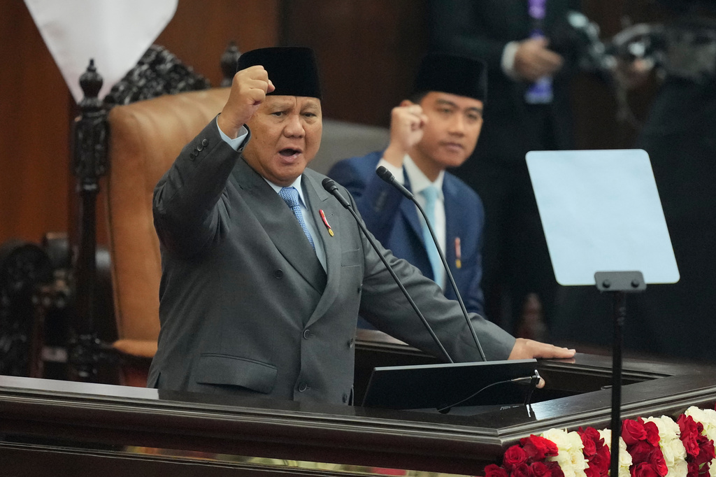 Indonesian President Prabowo Subianto raises his fist while delivering his annual State of the Nation Address ahead of the country's Independence Day at the parliament building in Jakarta, Indonesia, Friday, Aug. 14, 2026. (AP Photo/Dita Alangkara)