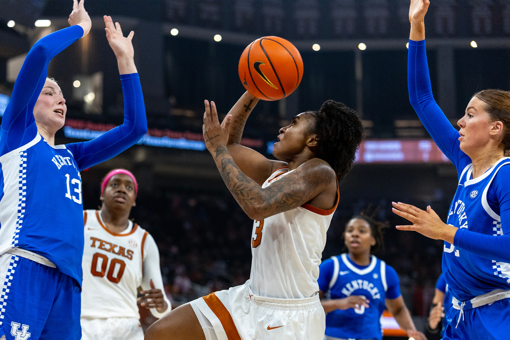 Texas guard Rori Harmon (3) looks to score between Kentucky center Clara Strack (13) and forward Amelia Hassett, right, during the second half of an NCAA college basketball game Monday, Feb. 9, 2026, in Austin, Texas. (AP Photo/Stephen Spillman)