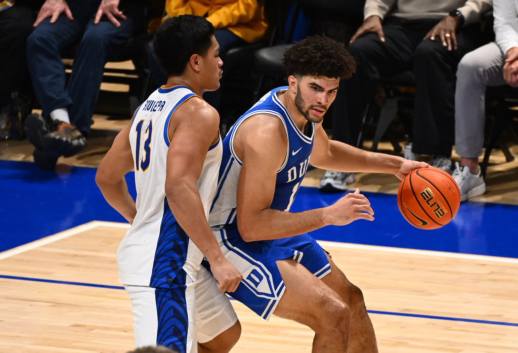 Duke's Cameron Boozer (12) dribbles as Pittsburgh's Roman Siulepa (13) defends in the second half of an NCAA college basketball game in Pittsburgh, Tuesday, Feb. 10, 2026. (AP Photo/Justin Berl)