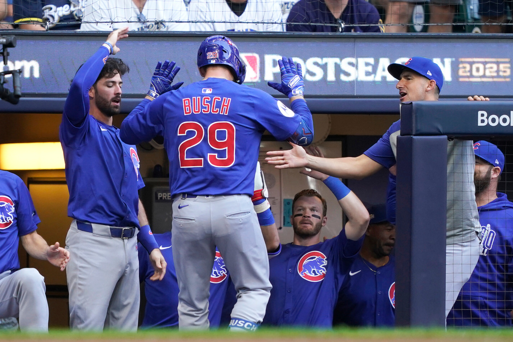 Chicago Cubs' Michael Busch (29) high-fives teammates after hitting a home run during the first inning in Game 1 of baseball's National League Division Series against the Milwaukee Brewers, Saturday, Oct. 4, 2025, in Milwaukee. (AP Photo/Kayla Wolf)