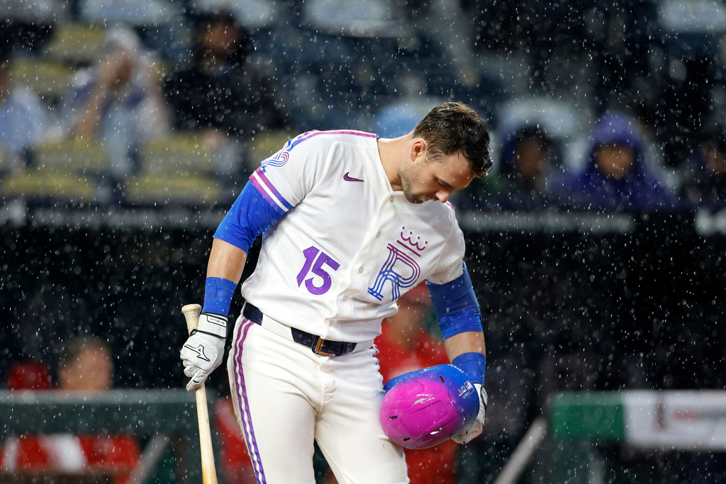 Kansas City Royals batter Lane Thomas wipes off his helmet during a downpour during in the seventh inning of a baseball game against the Los Angeles Angels in Kansas City, Mo., Sunday, April 26, 2026. (AP Photo/Colin E. Braley)