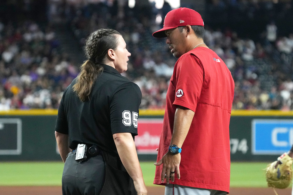 MLB home plate umpire Jen Pawol (95) talks to Los Angeles Angels manager Kurt Suzuki in the fifth inning of a baseball game against the Arizona Diamondbacks, Wednesday, June 17, 2026, in Phoenix. (AP Photo/Rick Scuteri)