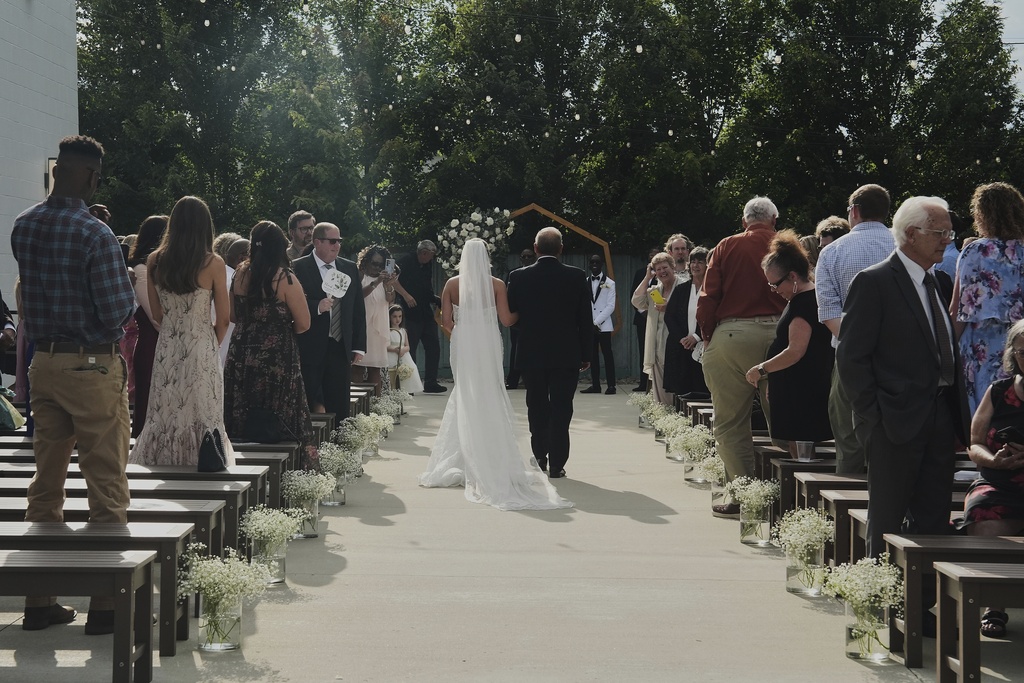 Kayla McDonald walks down the aisle with her father, Chris, during her wedding Saturday, Aug. 23, 2025, in Newtown, Ohio. (AP Photo/Joshua A. Bickel)