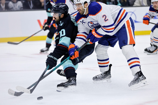 Edmonton Oilers defenseman Evan Bouchard (2) and Seattle Kraken center Matty Beniers (10) collide in the first period of an NHL hockey game Saturday, Oct. 25, 2025, in Seattle. (AP Photo/John Froschauer) Edmonton Oilers defenseman Evan Bouchard (2) and Seattle Kraken center Matty Beniers (10) collide in the first period of an NHL hockey game Saturday, Oct. 25, 2025, in Seattle. (AP Photo/John Froschauer)