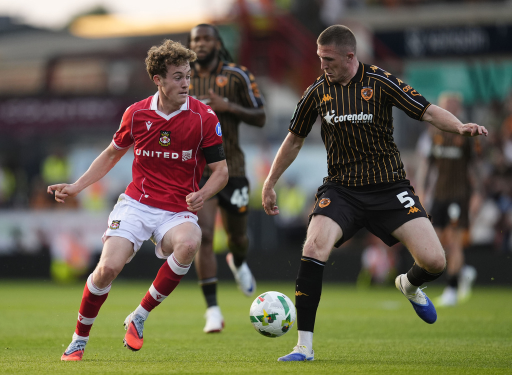 Wrexham's Harry Ashfield, left, and Hull City's John Lundstram in action during the English League Cup first round soccer match between Wrexham and Hull City at SToK Racecourse, Wrexham, Wales, Tuesday Aug. 12, 2025. (Nick Potts/PA via AP)