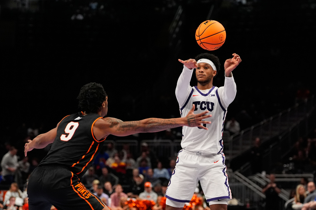 TCU's Micah Robinson, right, passes over Oklahoma State's Anthony Roy (9) during the second half of an NCAA college basketball game in the second round of the Big 12 Conference tournament Wednesday, March 11, 2026, in Kansas City, Mo. (AP Photo/Charlie Riedel)
