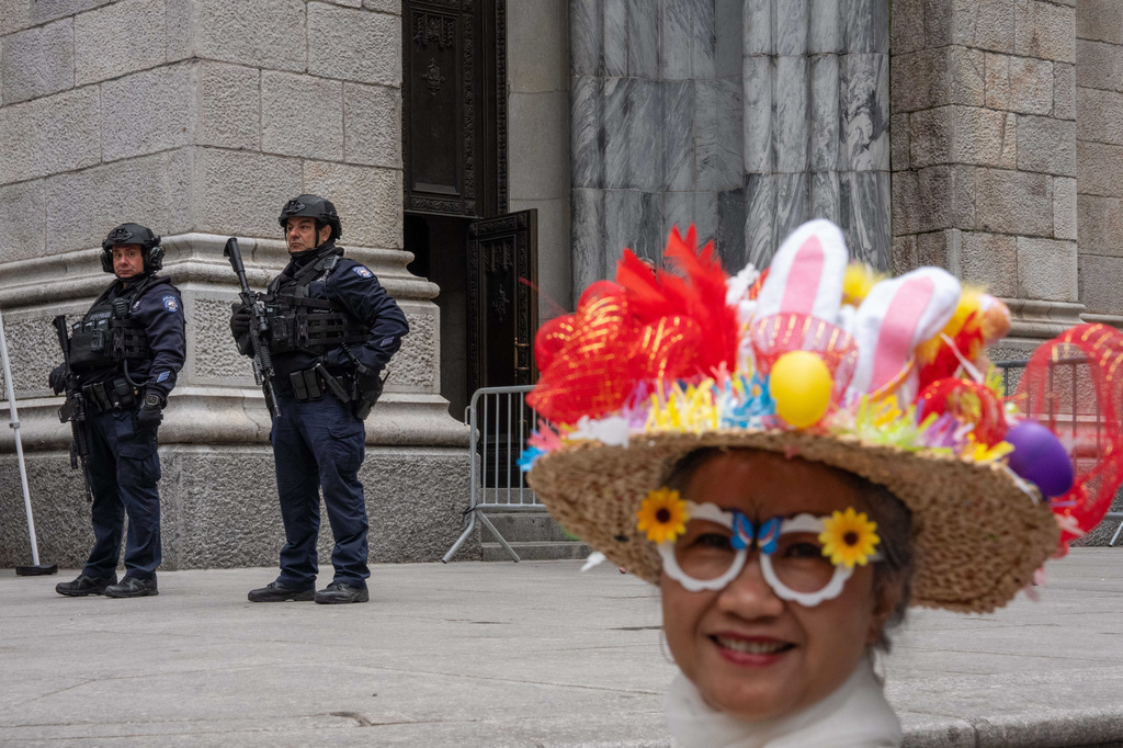 Heavily armed New York City Police Department (NYPD) officers stand guard outside of St. Patrick's Cathedral, as Lisa Neville takes part in the Easter Bonnet Parade on Fifth Avenue, Sunday, April 5, 2026, in New York. (AP Photo/Adam Gray)