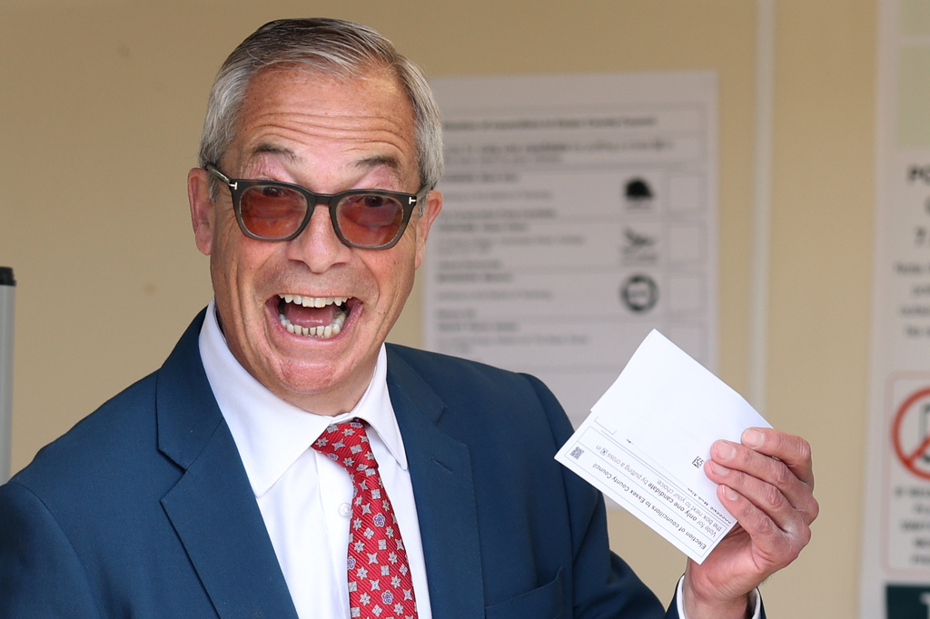 Britain's Reform Party leader Nigel Farage poses for photographers with his poll card at a polling station in Walton on the Naze, England, Thursday, May 7, 2026 before he casts his vote in the local elections.(AP Photo/Richard Pelham)
