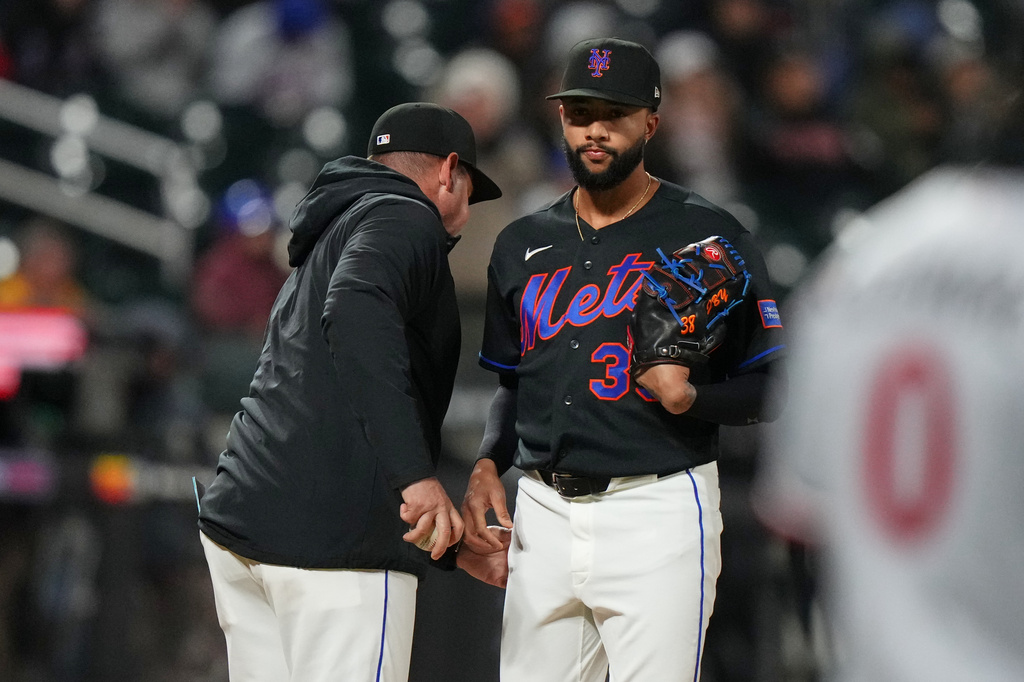 New York Mets pitcher Devin Williams, right, hands the ball to manager Carlos Mendoza as he leaves during the ninth inning of a baseball game against the Minnesota Twins Tuesday, April 21, 2026, in New York. (AP Photo/Frank Franklin II)