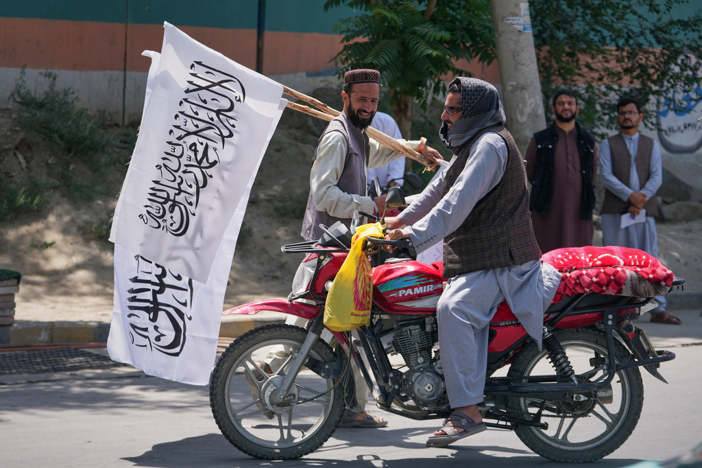 A man offers Taliban flags for sale ahead of celebrations marking the fifth anniversary of the U.S. withdrawal from Afghanistan and the start of Taliban rule, in Kabul, Afghanistan, Thursday, Aug. 13, 2026. (AP Photo/Siddiqullah Alizai)