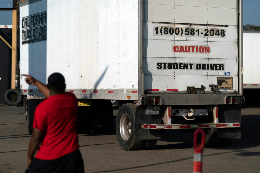 FILE - A student driver helps his classmate steer the wheel into the right direction as they practice driving in reverse in Calif., Nov. 17, 2021. (AP Photo/Jae C. Hong, File)
