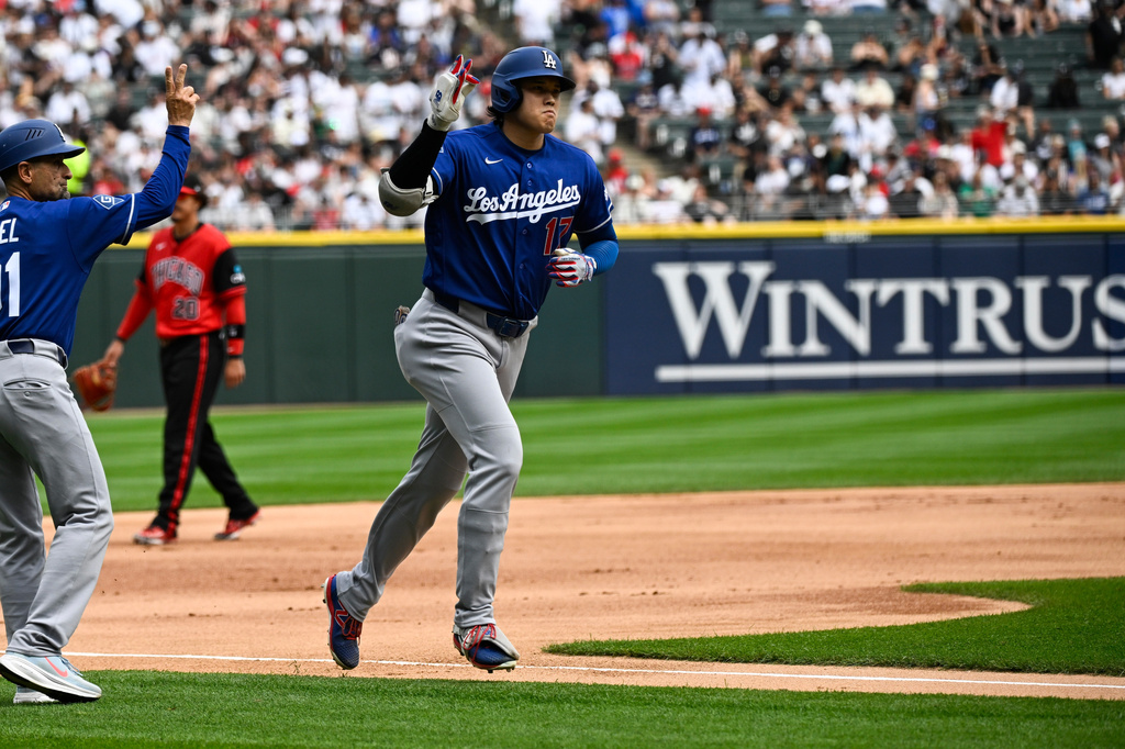Los Angeles Dodgers' Shohei Ohtani, right, of Japan, gestures after he hit a home run during the first inning of a baseball game against the Chicago White Sox, Saturday, June 13, 2026, in Chicago. (AP Photo/Matt Marton)