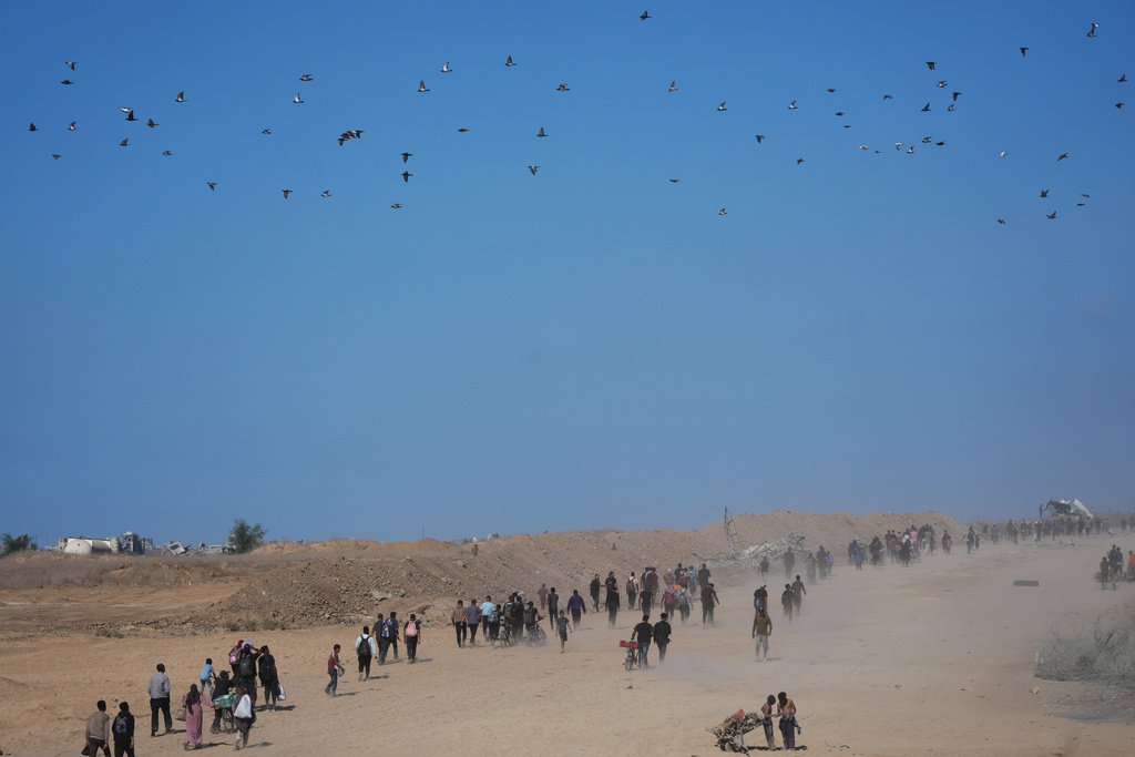 Displaced Palestinians walk toward Gaza City, in the northern Gaza Strip, Friday, Oct. 10, 2025, after Israel and Hamas agreed to a pause in their war and the release of the remaining hostages. (AP Photo/Jehad Alshrafi)
