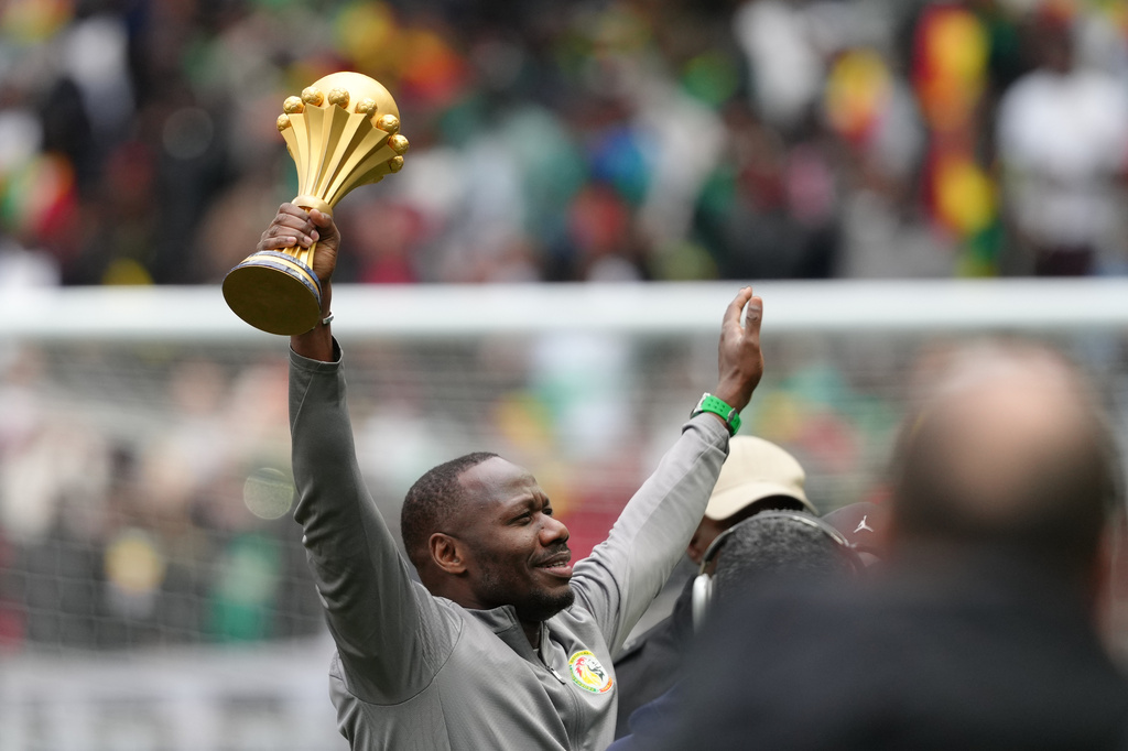 Senegal coach Pape Thiaw holds the Africa Cup of Nations trophy ahead of the international friendly soccer match between Senegal and Peru in Saint-Denis, outside of Paris, Saturday, March 28, 2026. (AP Photo/Aurelien Morissard)