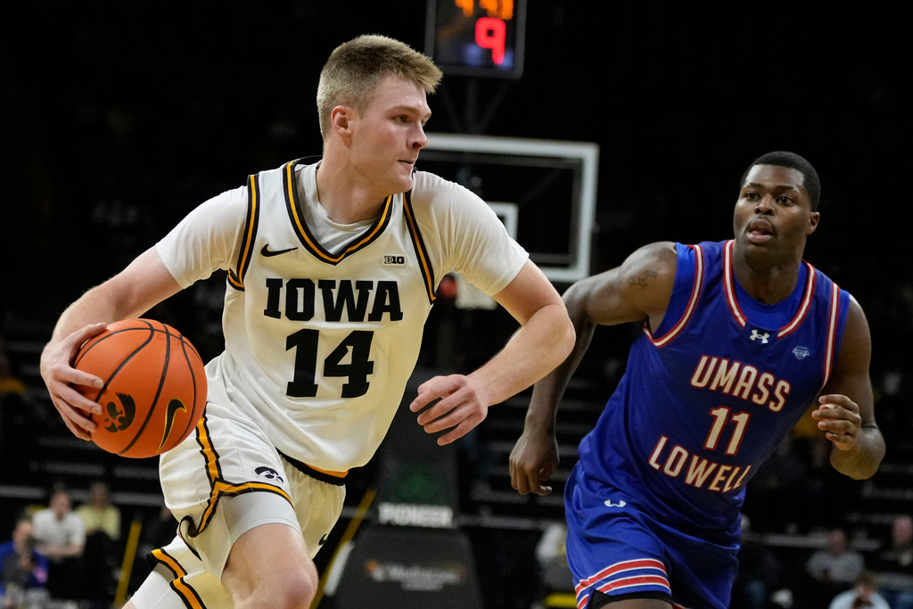 Iowa guard Bennett Stirtz (14) drives to the basket past UMass-Lowell guard Xavier Spencer (11) during the first half of an NCAA college basketball game, Monday, Dec. 29, 2025, in Iowa City, Iowa. (AP Photo/Charlie Neibergall)