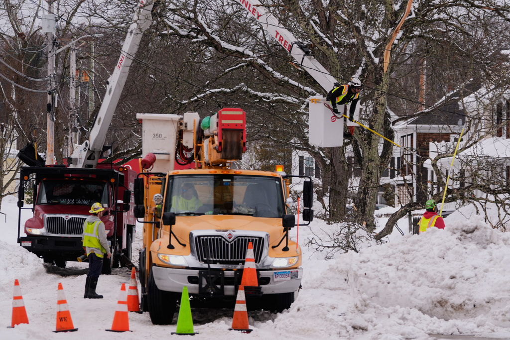 A electrical line crew from Connecticut and a tree clearing crew from Rhode Island work to restore power after a winter storm dumped more than two feet of snow across the region, Wednesday, Feb. 25, 2026, in Plymouth, Mass. (AP Photo/Charles Krupa)