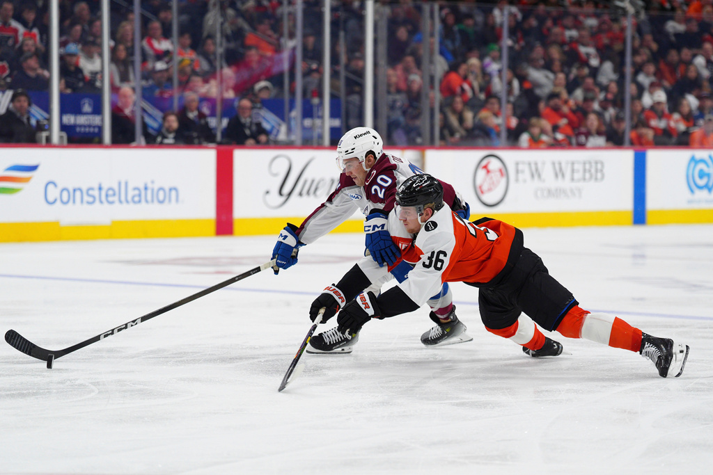 Philadelphia Flyers' Emil Andrae (36) dives to knock the puck from Colorado Avalanche's Ross Colton (20) during the third period of an NHL hockey game, Sunday, Dec. 7, 2025, in Philadelphia. (AP Photo/Derik Hamilton)