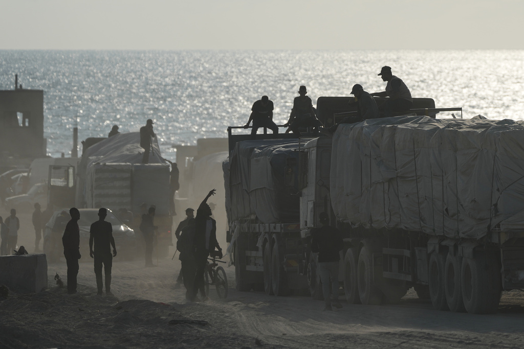 Trucks carrying humanitarian aid drive through Gaza City after entering from Israel via the Zikim crossing, northern Gaza Strip, Thursday, Nov. 13, 2025. (AP Photo/Jehad Alshrafi)