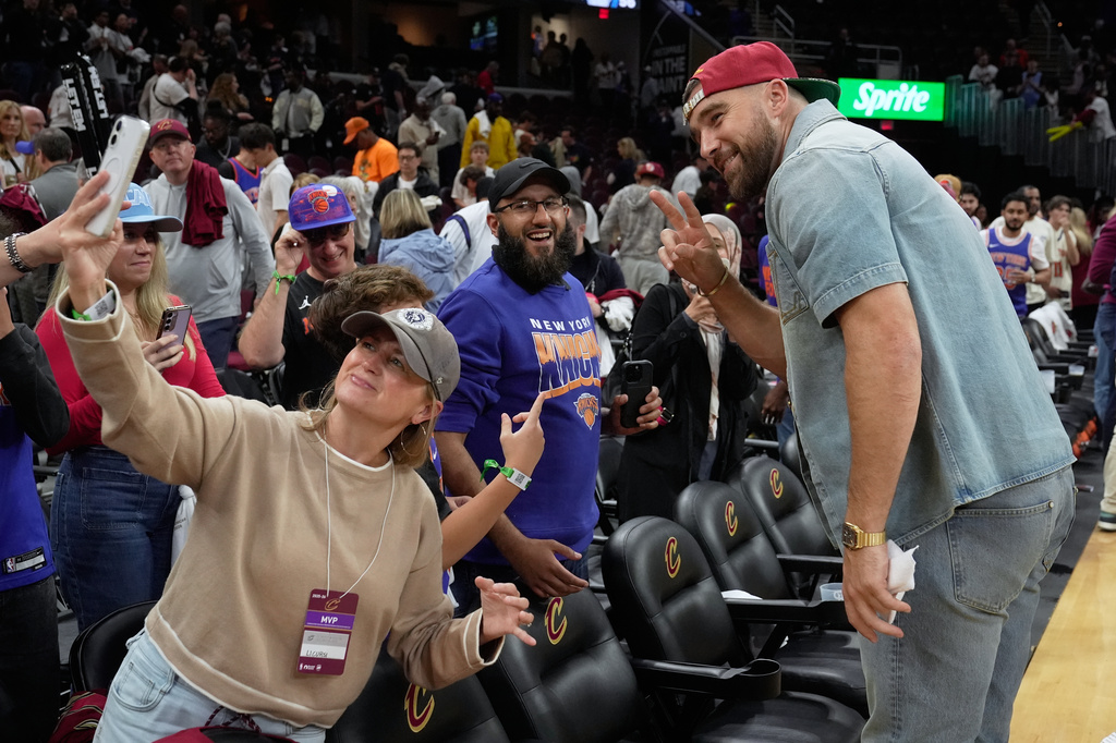 Travis Kelce takes photos with fans after Game 3 in the Eastern Conference finals NBA basketball playoffs series between the New York Knicks and the Cleveland Cavaliers in Cleveland, Saturday, May 23, 2026. (AP Photo/Sue Ogrocki)