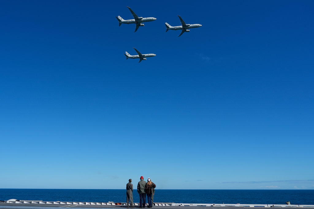 President Donald Trump and first lady Melania Trump watch a flight of P-8A Poseidon aircraft during a naval sea power demonstration, part of the Navy's 250th anniversary celebration, aboard the USS George H.W. Bush aircraft carrier in the Atlantic Ocean off the coast of Norfolk, Va., Sunday, Oct. 5, 2025. (AP Photo/Alex Brandon)