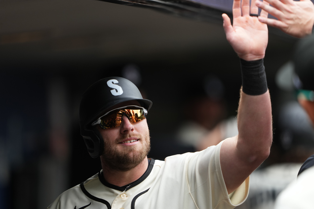 Seattle Mariners' Luke Raley celebrates in the dugout after scoring on a sacrifice fly from Mariners' Brendan Donovan during the third inning of a baseball game against the Houston Astros, Sunday, April 12, 2026, in Seattle. (AP Photo/Lindsey Wasson)