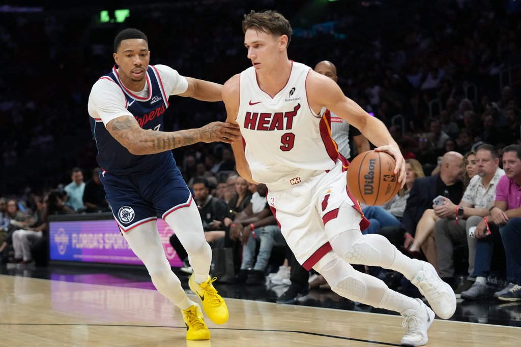 Miami Heat guard Pelle Larsson (9) drives to the basket as Los Angeles Clippers guard Jordan Miller, left, defends during the first half of an NBA basketball game, Monday, Dec. 1, 2025, in Miami. (AP Photo/Lynne Sladky)