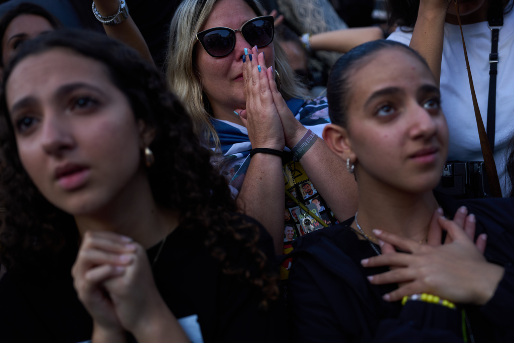 People react as they watch a live broadcast of Israeli hostages released from Hamas captivity in the Gaza Strip, at a plaza known as hostages square in Tel Aviv, Israel, Monday, Oct. 13, 2025. (AP Photo/Oded Balilty)
