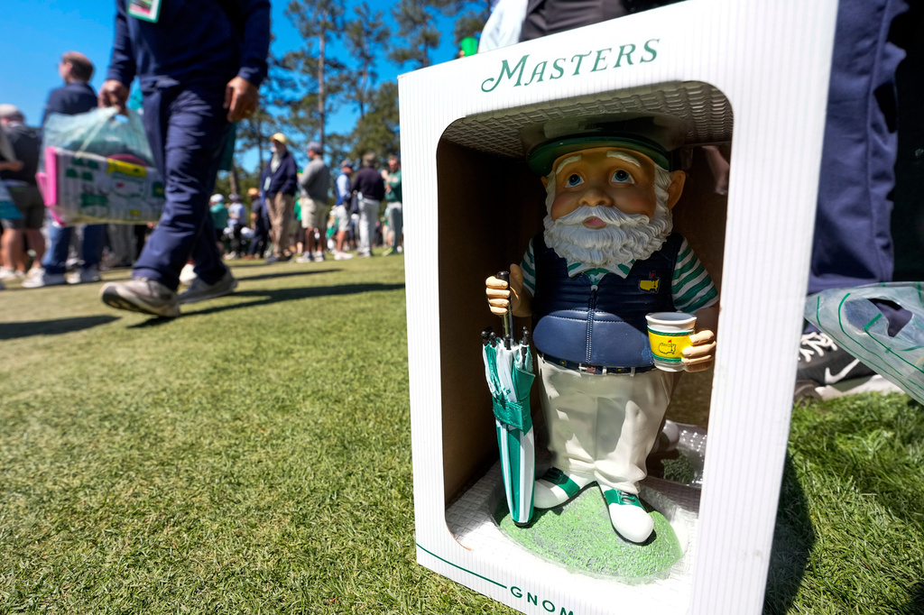 Patrons walk past this years gnome on the 12th hole during the first round of the Masters golf tournament at the Augusta National Golf Club, Thursday, April 9, 2026, in Augusta, Ga. (AP Photo/David J. Phillip)