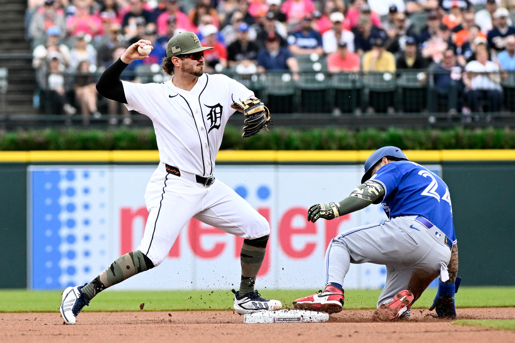 Detroit Tigers second baseman Zach McKinstry, left, throws to first base after forcing out Toronto Blue Jays' Yohendrick Pinango at second base during the first inning of a baseball game, Saturday, May 16, 2026, in Detroit. (AP Photo/Jose Juarez)